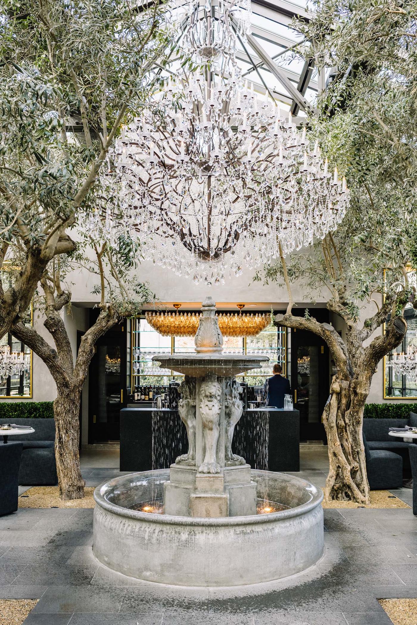 outdoor restaurant with fountain under chandelier