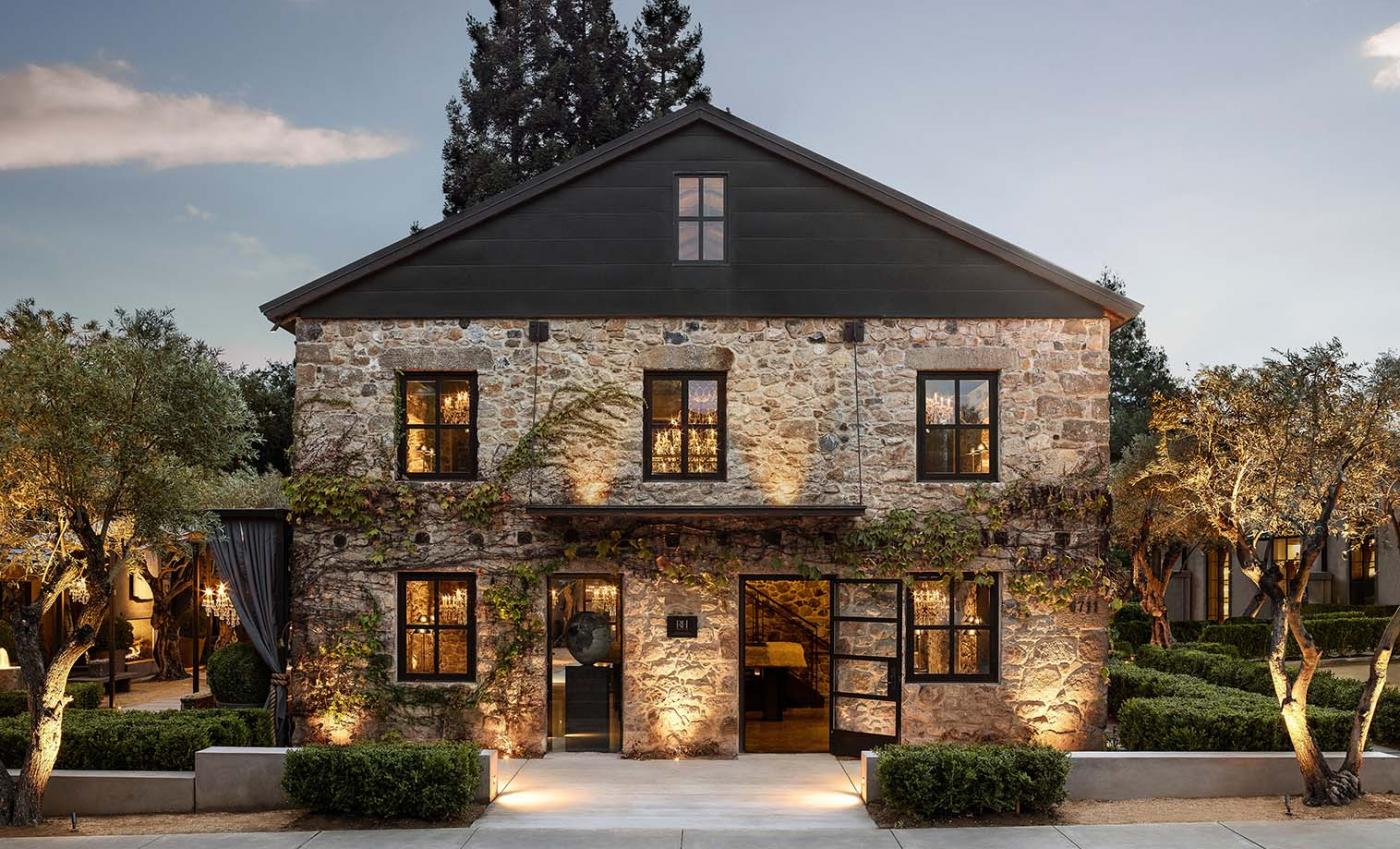 cobblestone building surrounded by greenery and lights