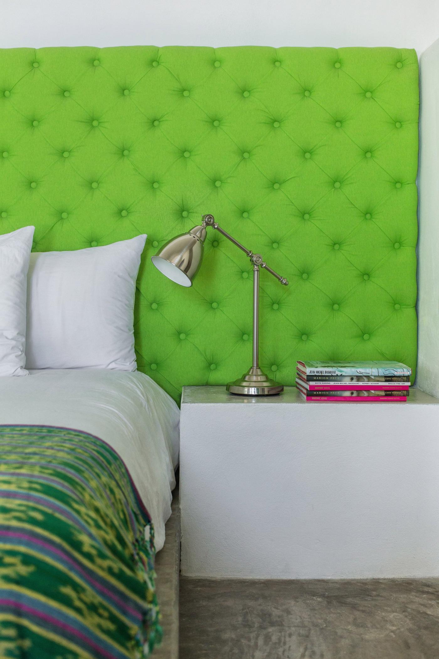 hotel bedside table with stacked books and lamp displayed