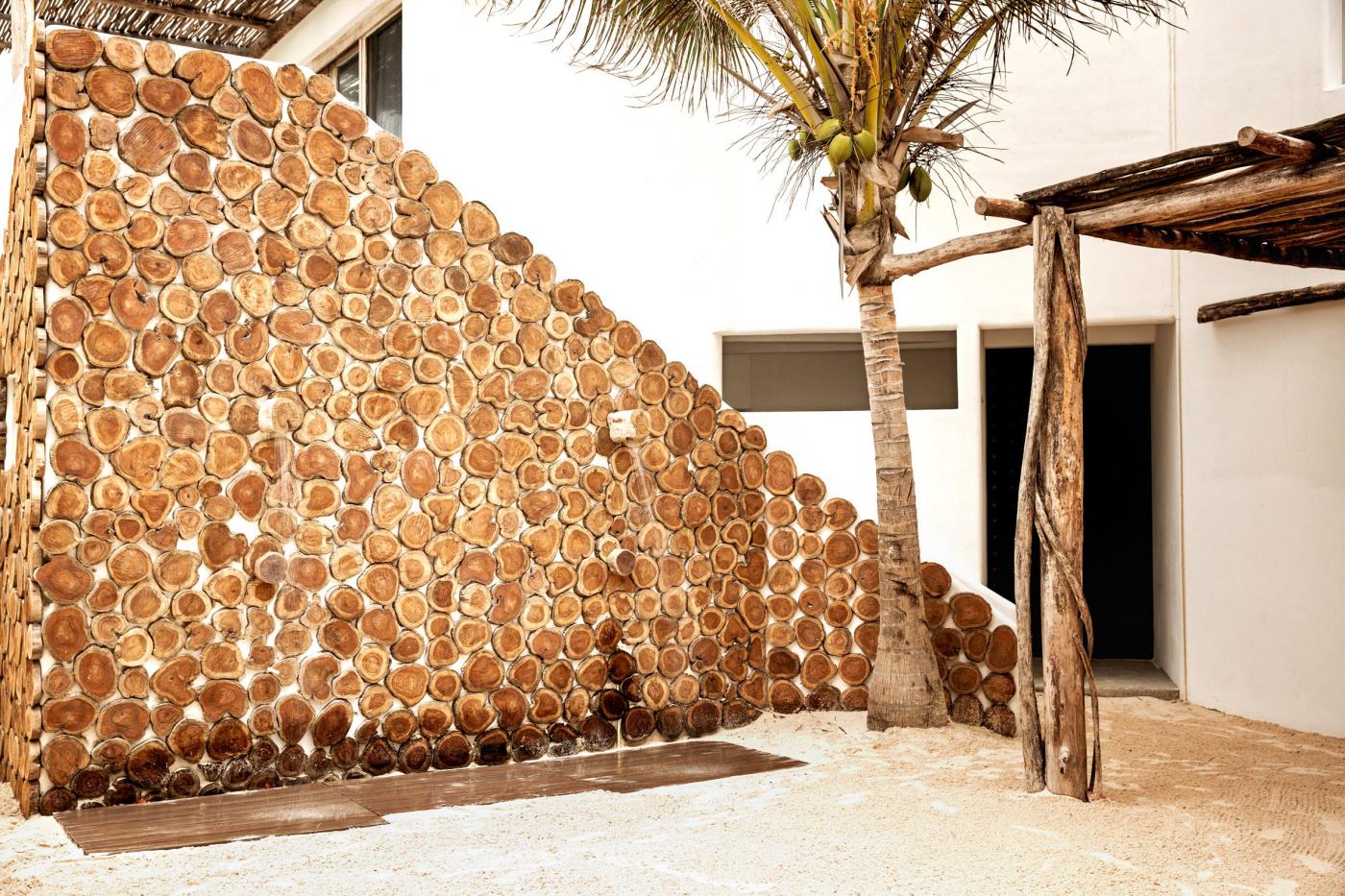 outdoor villa of hotel lined with a wooden wall and palm trees