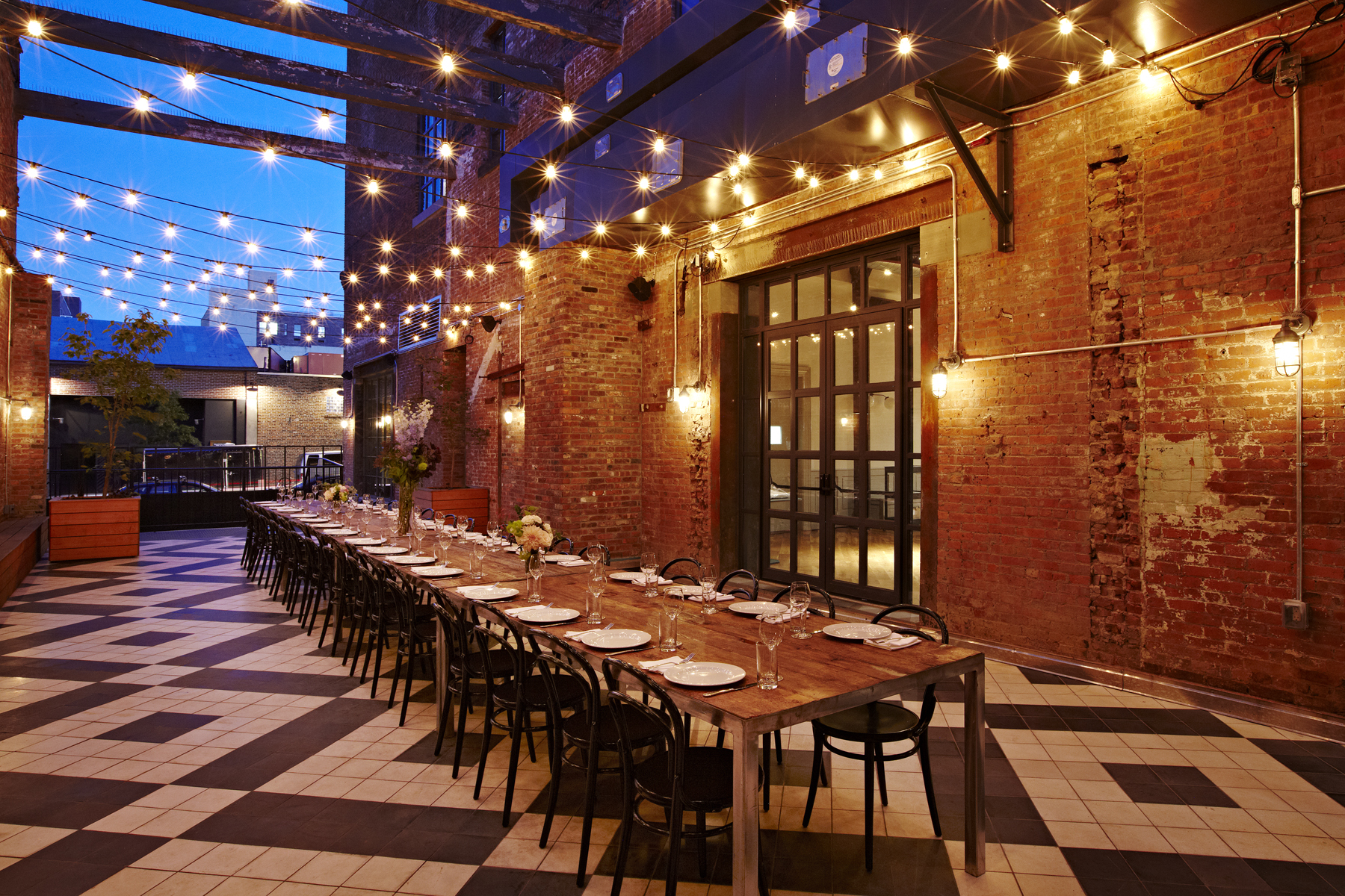 The Garden Terrace is an open-air courtyard framed by original brick walls and climbing greenery.