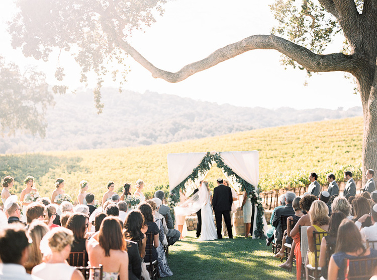 Outdoor wedding ceremony with beautiful vineyard views.