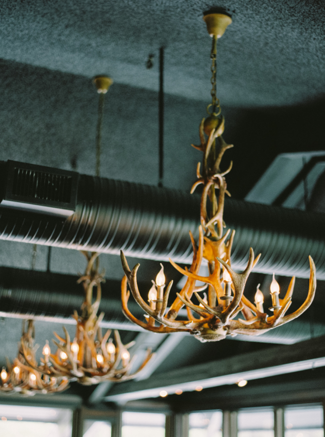 Exuding rustic elegance, the interior is illuminated with ornate elk antler chandeliers and accessorized with a grand stone fireplace.