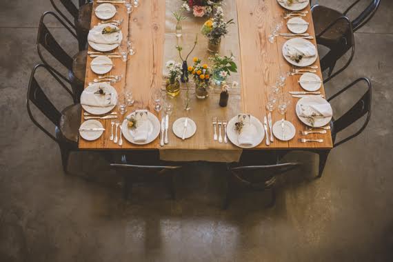 Large wooden rustic table with industrial metal chairs.