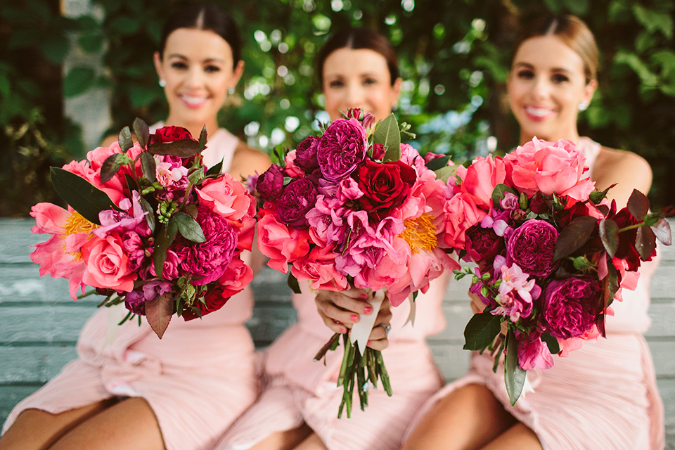 Bright coral bridesmaids bouquets.