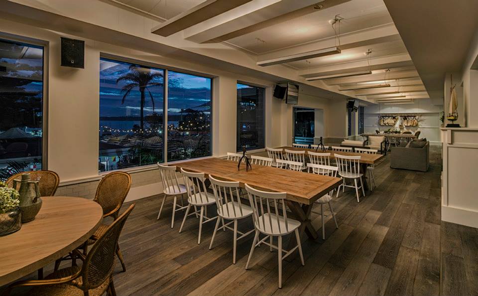 The room boasts crisp white walls, floor to ceiling windows with spectacular harbour views, grey timber flooring, a white marble bar and nautical finishing’s.