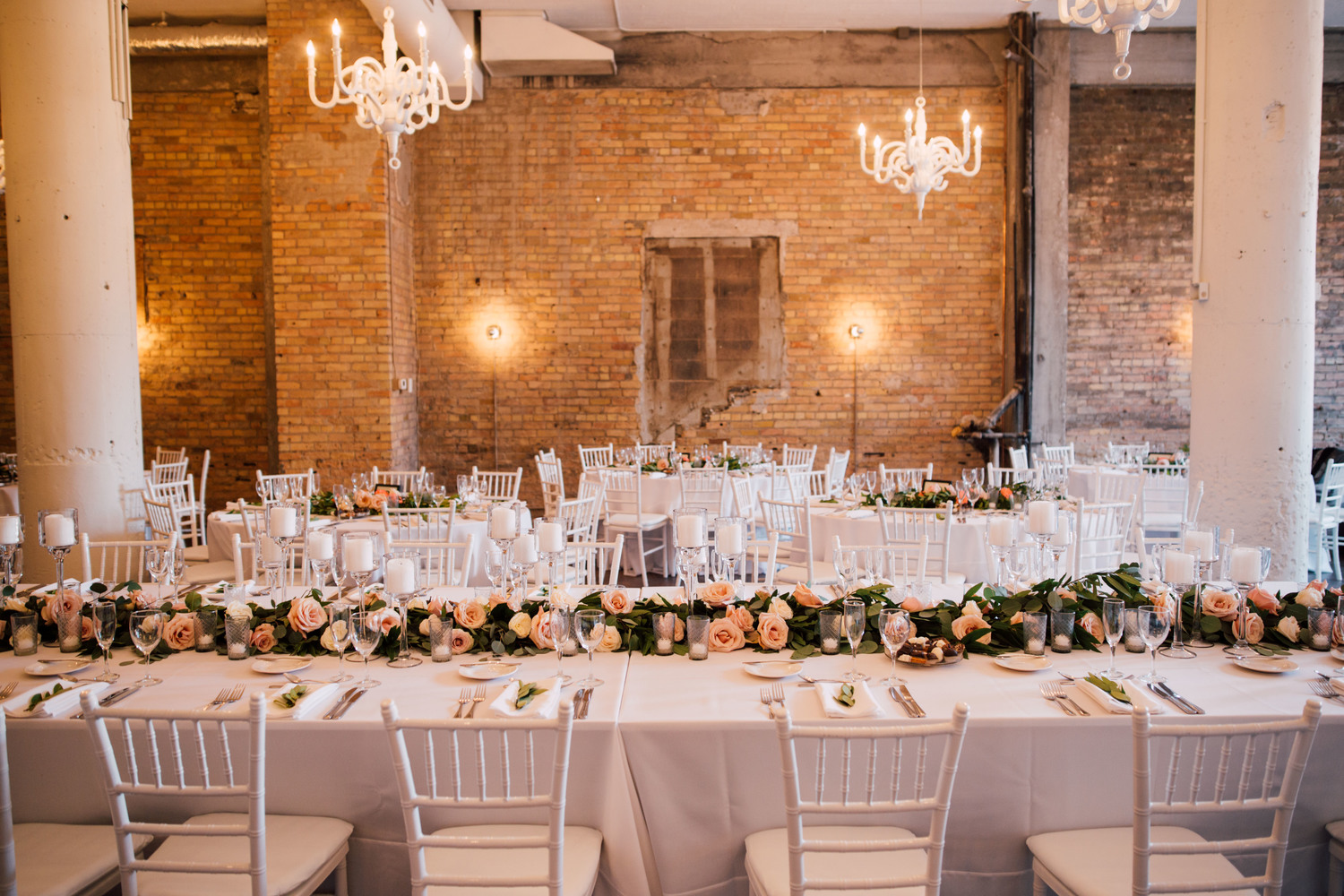 16 chandeliers sparkle from the vaulted ceiling, while exposed brick walls frame a working, glass garage door that lead to a quaint European-style back alley.