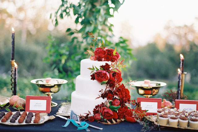 Beautiful wedding cake with deep red flowers.