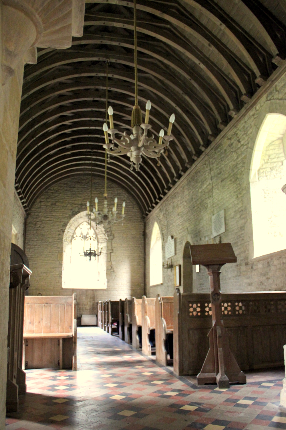 The small Norman church is a short distance from the Manor house and village, is easy to miss under a canopy of trees.
