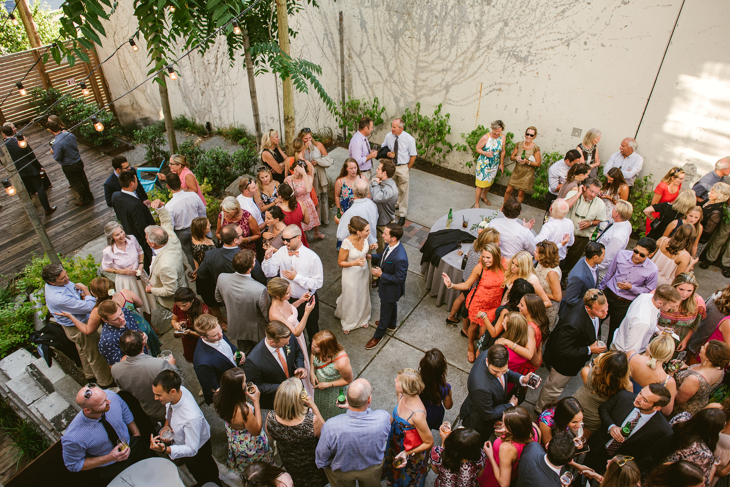Perfect for outdoor cocktail receptions, Fremont Foundry houses a charming, secluded courtyard with wood decking, grasscrete, elegant string canopy lights, cement garden features, and funky repurposed metal forging equipment.