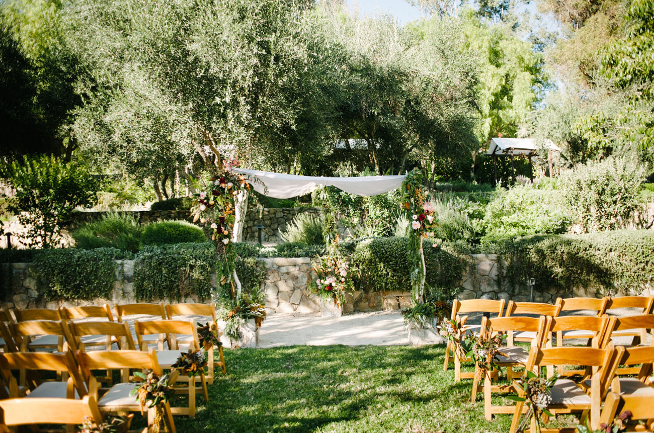 Outdoor wedding ceremony surrounded by luscious greenery.