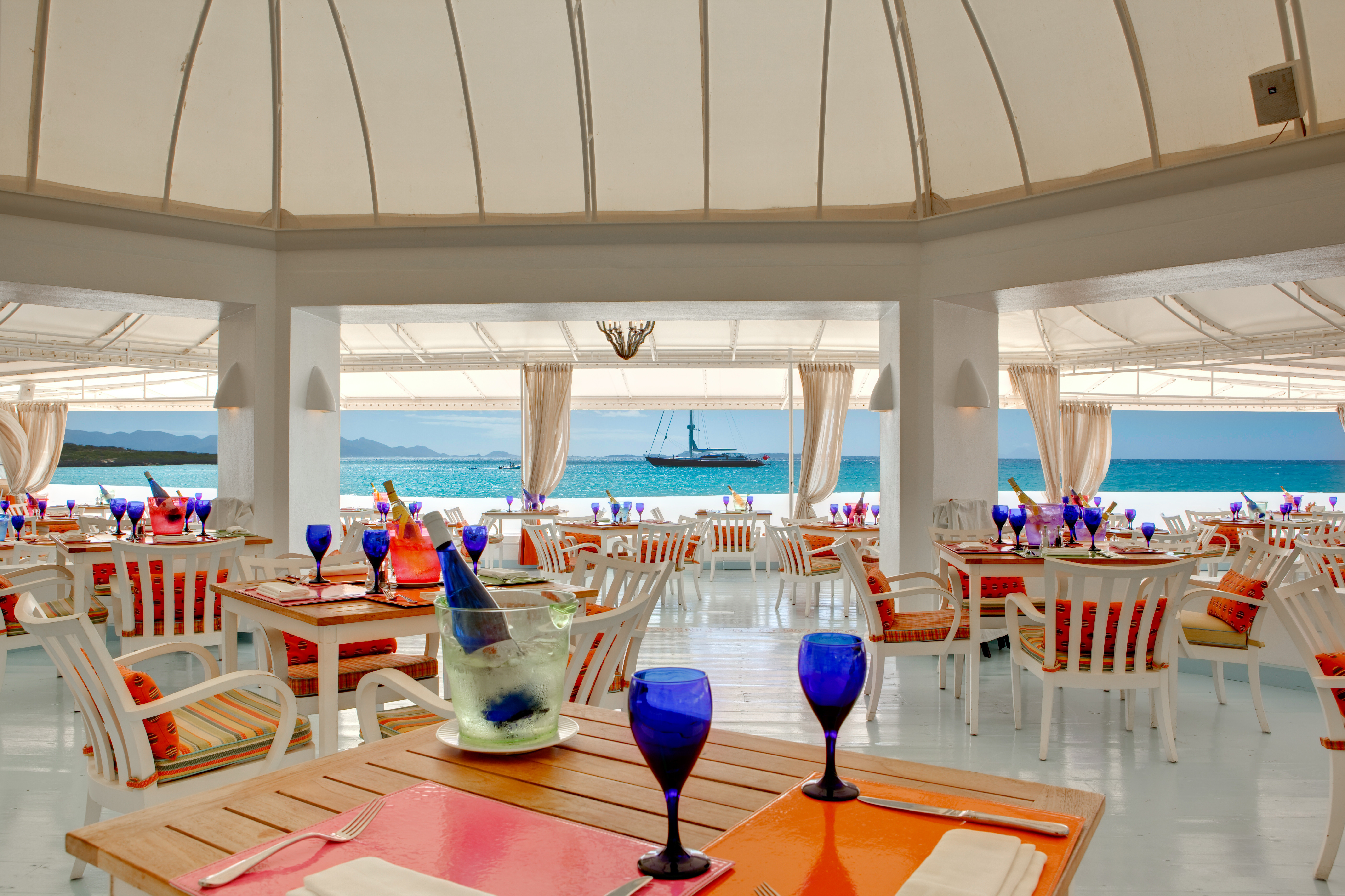 Blue, with its breathtaking panoramic views of St. Maarten and the Caribbean Sea, has been recently refurbished with a bright white and pale azure backdrop accented with bright sorbet-colored chairs.