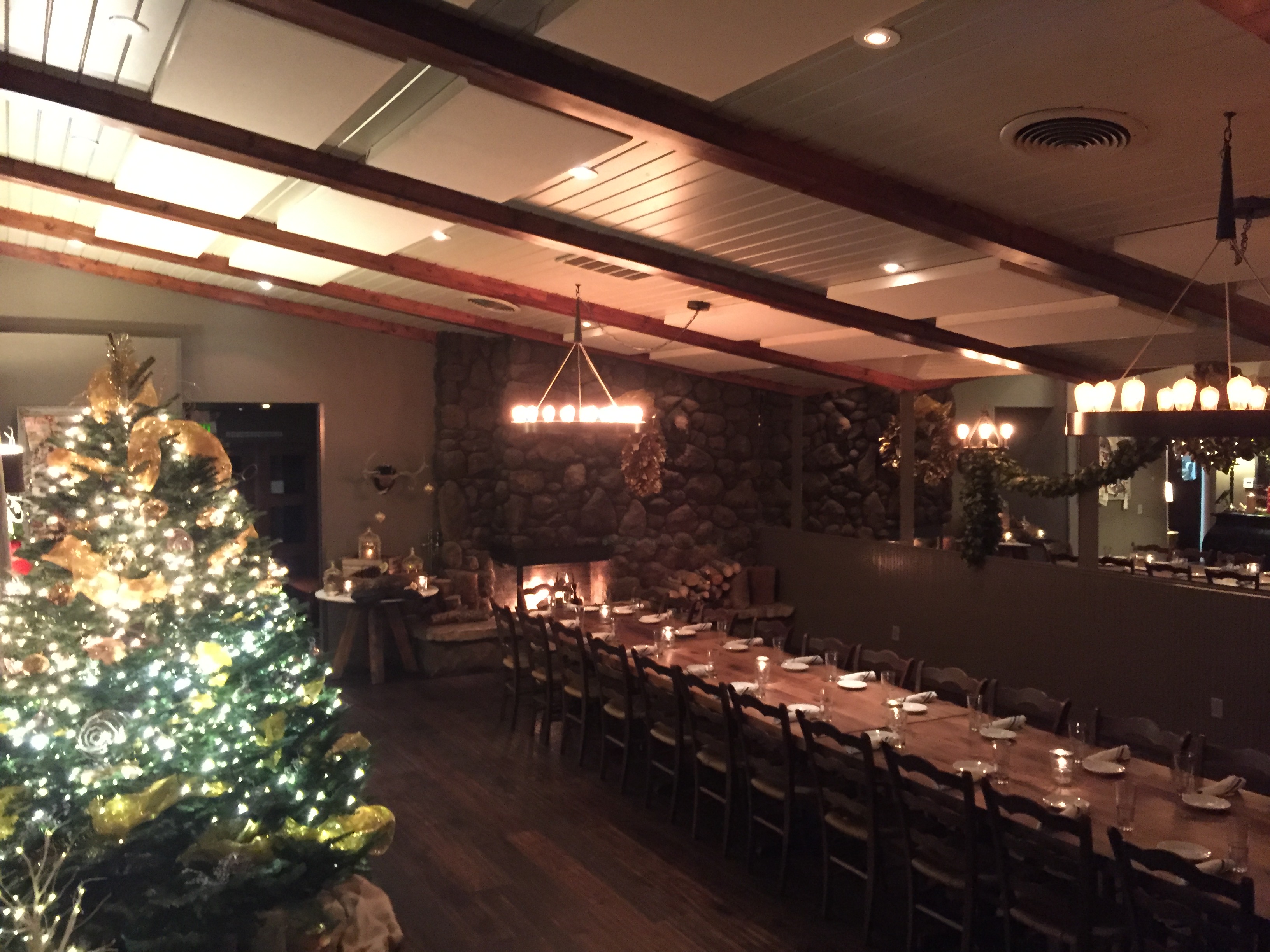 The indoor banquet room has dark, wide-plank wood floors and a wood burning fireplace.
