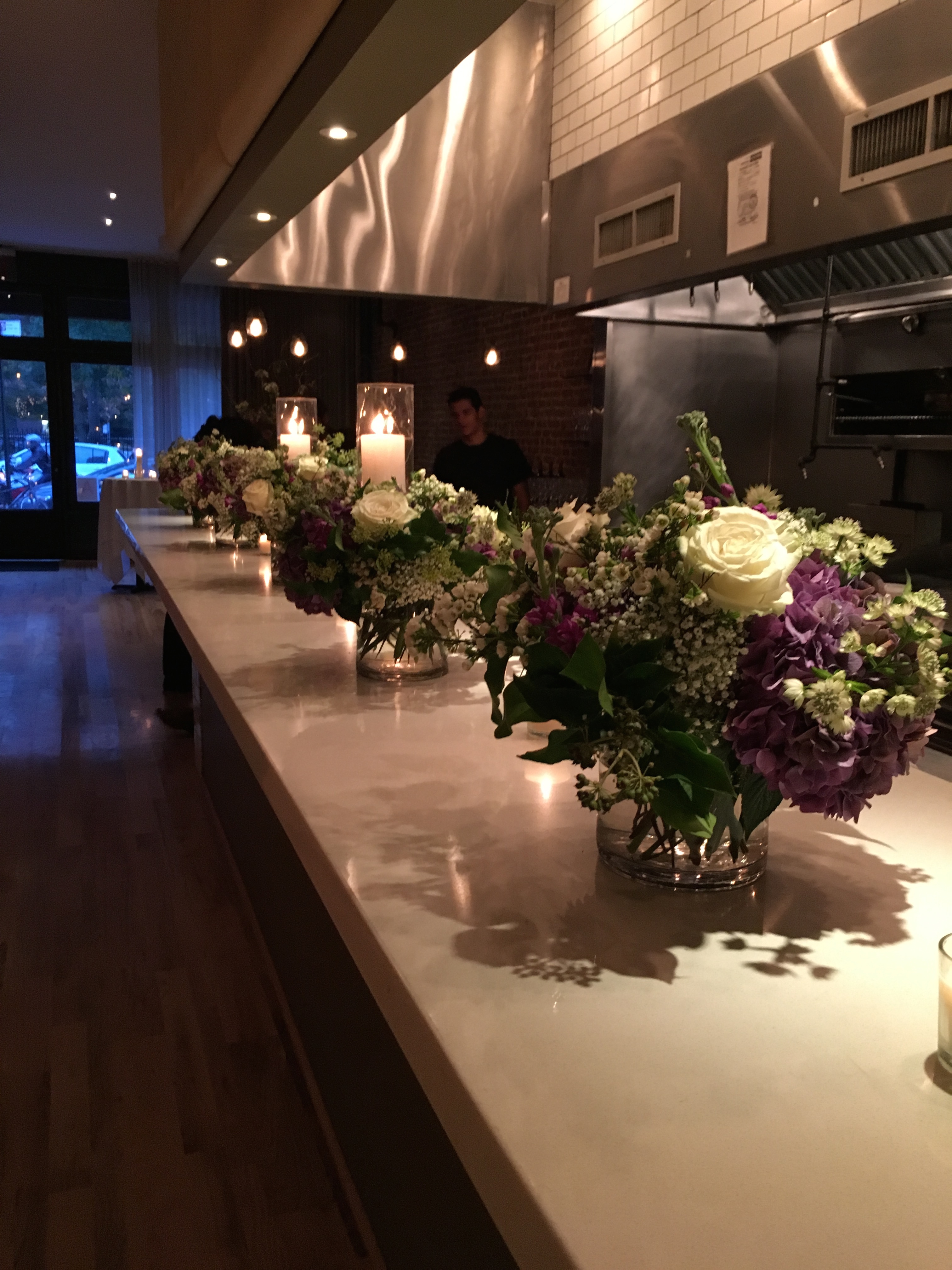 The front reception area is anchored by a solid bubinga wood bar that leads past an open kitchen to the back dining area, where as many as 50 can be comfortably accommodated for a seated event.