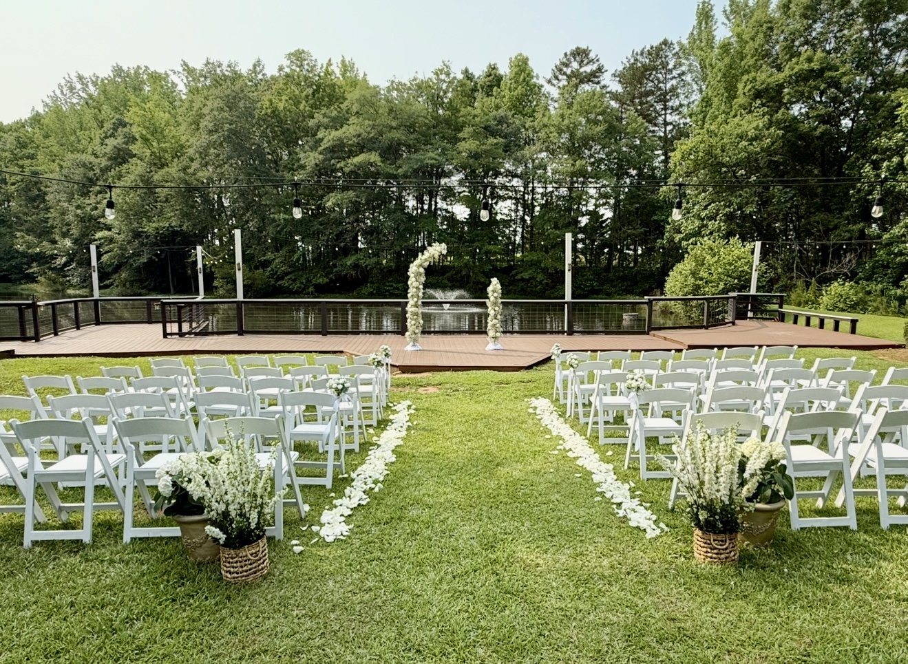 The pond serves as the enchanting backdrop for an elegant afternoon wedding ceremony.